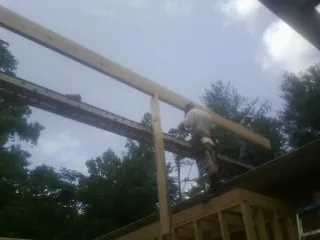 Carpenter setting a ridge beam over a new addition frame — Ice Dam Removal by Roofing Brothers in Adamsburg