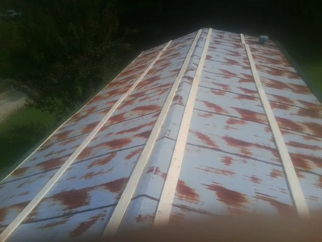 Rusted metal roof panels with new wood purlins before replacement — Storm Damage Roof Repair in Adamsburg by Roofing Brothers