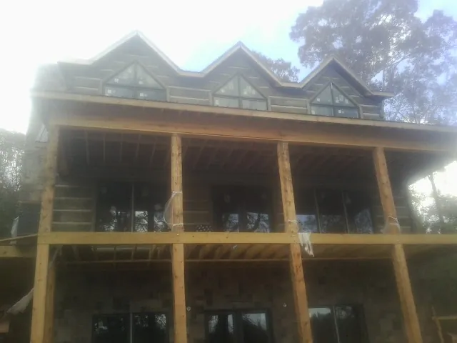 Dormers and porch framing on a large log home under construction — Roof Coating work by our crew in Adamsburg