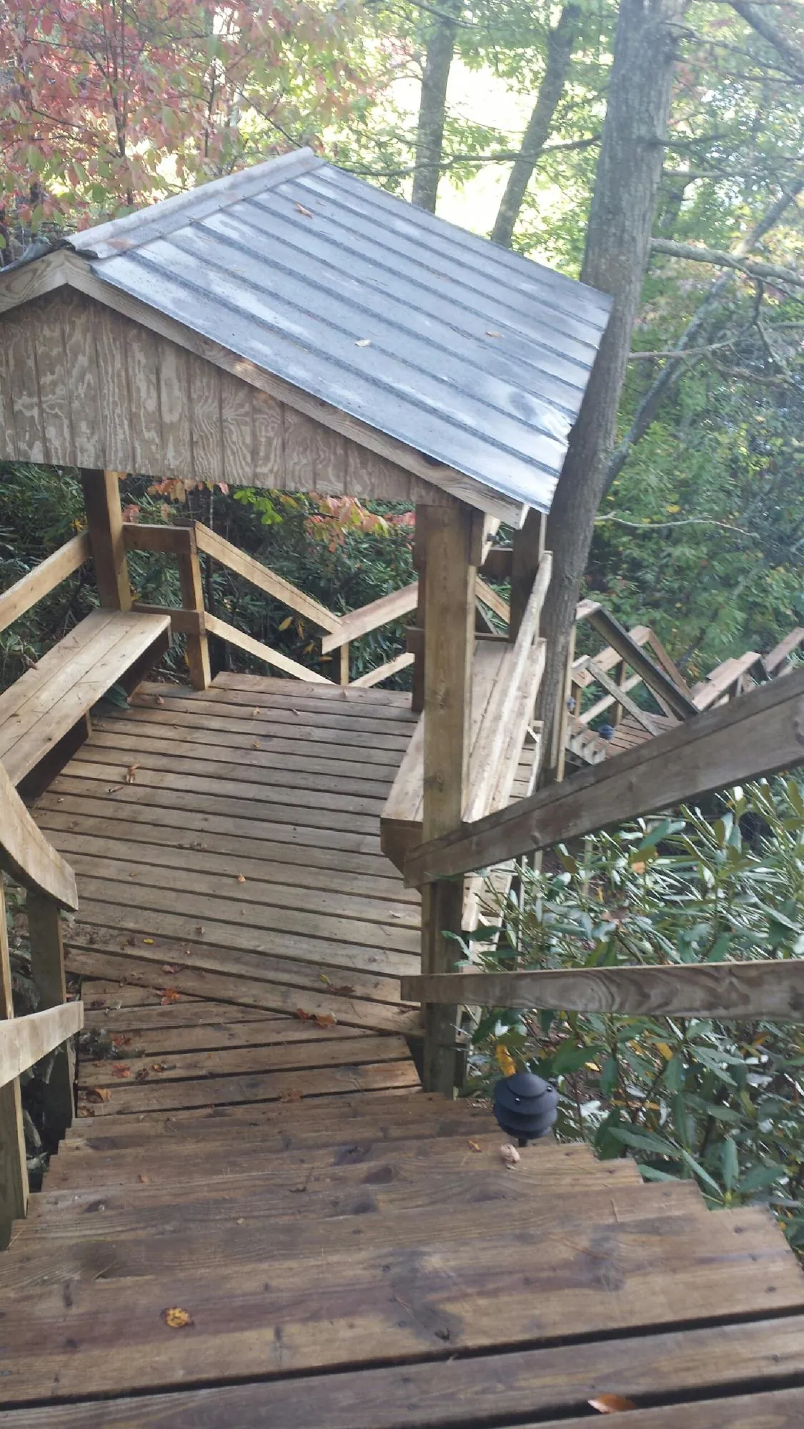 Metal roofed shelter over wooden steps on a wooded walkway — Skylight Repair & Installation work by our crew in Adamsburg