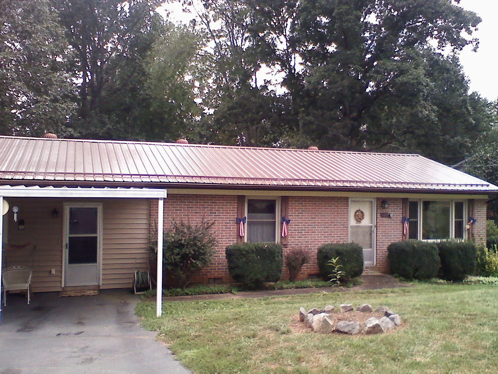 Bronze metal roof and carport on a brick ranch home — Roof Repair work by our crew in Adamsburg