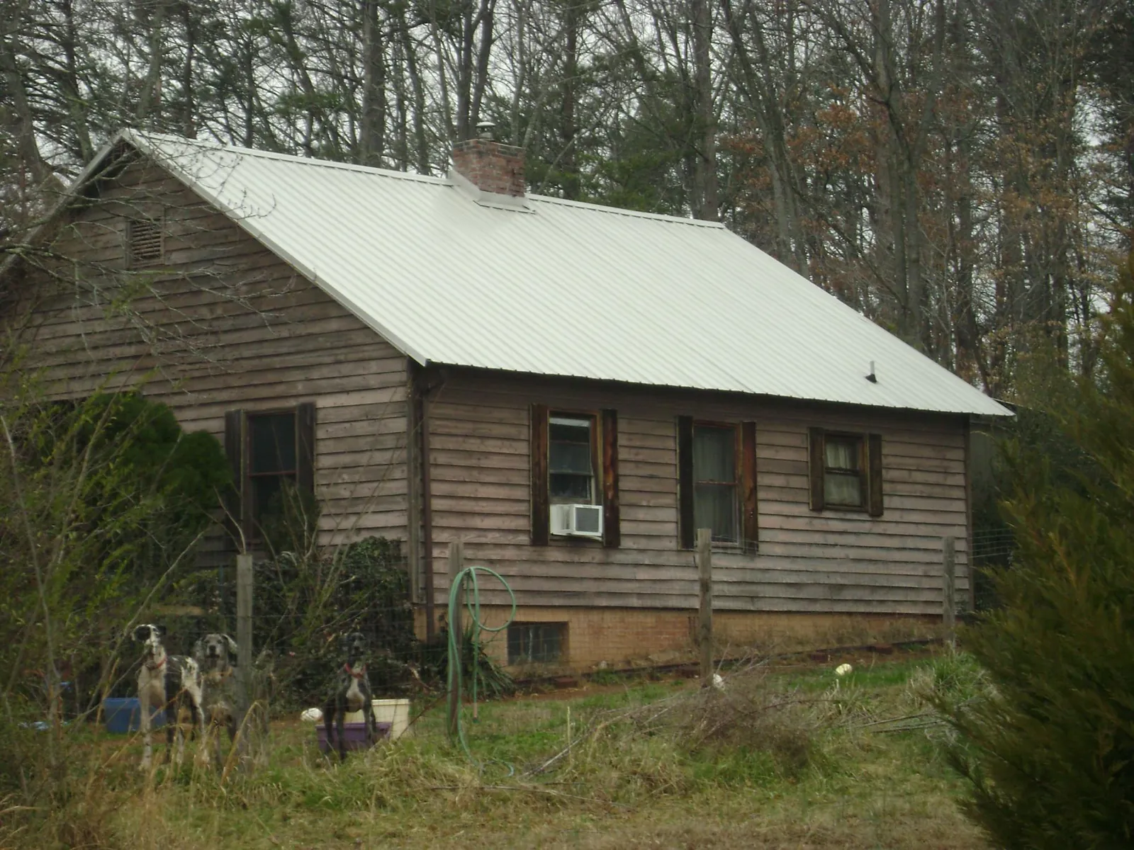 White metal roof on an old wood sided farmhouse, from a Metal Roof Installation job in Adamsburg
